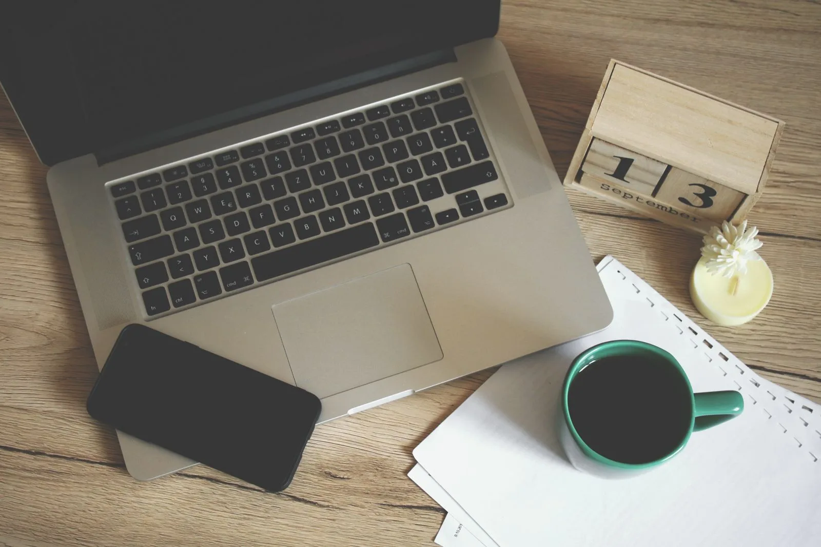 Laptop and papers on a desk, used to illustrate compressing a PDF without losing quality
